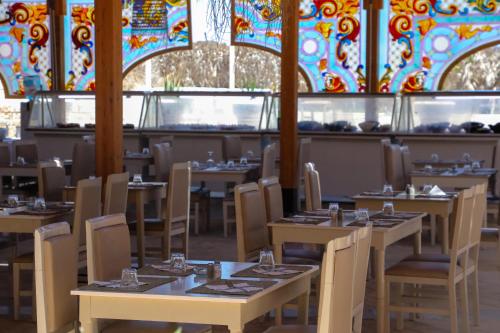 a dining room with tables and chairs and stained glass ceilings at Riadh Palms- Resort & Spa in Sousse