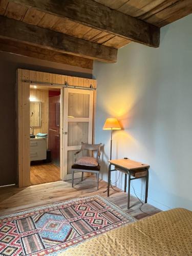 a bedroom with a bed and a table and a chair at Lamamas in Nonières