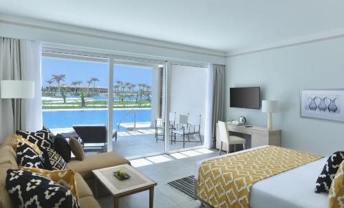 a hotel room with a bed and a living room at Steigenberger Resort Alaya Marsa Alam - Red Sea - Adults Friendly 16 Years Plus in Coraya Bay