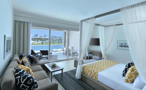 a hotel room with a bed and a couch at Steigenberger Resort Alaya Marsa Alam - Red Sea - Adults Friendly 16 Years Plus in Coraya Bay