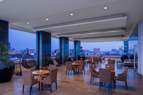 a restaurant with tables and chairs on a roof at Melia Makassar in Makassar