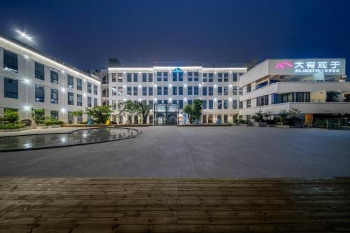 an empty parking lot in front of a large building at 大有观于All about Yu Hotel in Chongqing