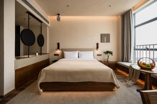 a bedroom with a large bed and a large window at 大有观于All about Yu Hotel in Chongqing