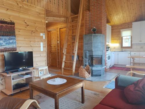 a living room with a fireplace in a log cabin at Kulkuri in Syöte