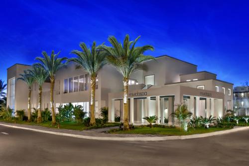 a building with palm trees in front of it at Steigenberger Resort Alaya Marsa Alam - Red Sea - Adults Friendly 16 Years Plus in Coraya Bay