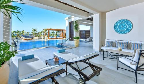 a patio with a table and chairs and a pool at Steigenberger Resort Alaya Marsa Alam - Red Sea - Adults Friendly 16 Years Plus in Coraya Bay