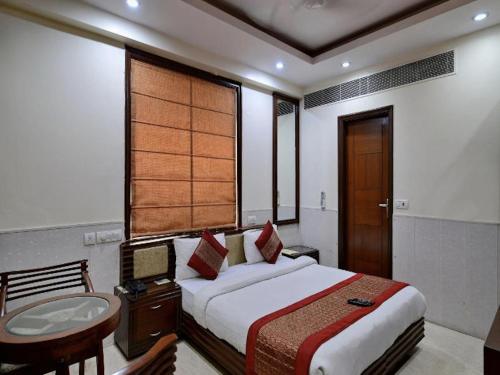 a bedroom with a bed and a bathroom with a sink at Daanish Residency in Karol Bagh Delhi Near Ganga Ram Hospital in New Delhi