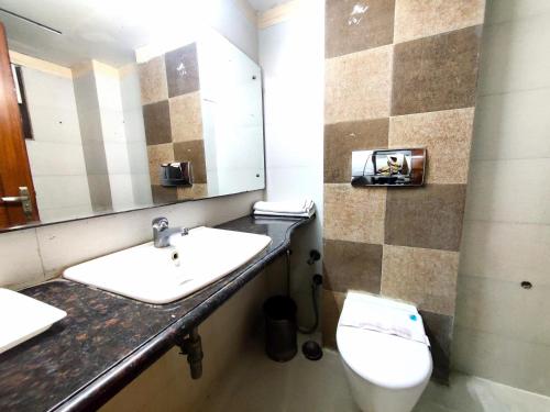 a bathroom with a sink and a toilet and a mirror at Daanish Residency in Karol Bagh Delhi Near Ganga Ram Hospital in New Delhi