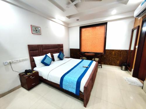 a bedroom with a large bed with blue pillows at Daanish Residency in Karol Bagh Delhi Near Ganga Ram Hospital in New Delhi