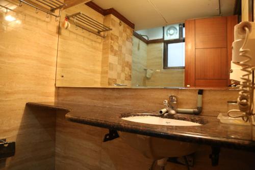 a bathroom with a sink and a mirror at Daanish Residency in Karol Bagh Delhi Near Ganga Ram Hospital in New Delhi