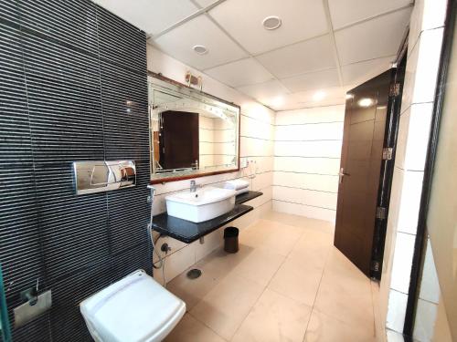 a bathroom with a sink and a toilet and a mirror at Daanish Residency in Karol Bagh Delhi Near Ganga Ram Hospital in New Delhi