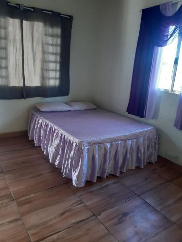 a bedroom with a bed with purple sheets and a window at Recharge your batteries Arca da Aliança Chalet in Limeira
