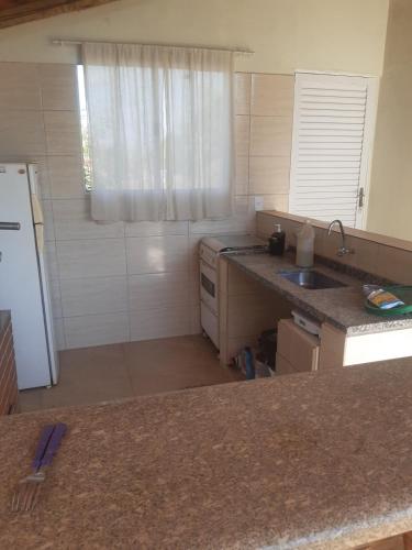 a kitchen with a sink and a white refrigerator at Recharge your batteries Arca da Aliança Chalet in Limeira