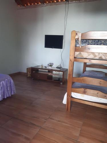 a room with a bunk bed and a television at Recharge your batteries Arca da Aliança Chalet in Limeira