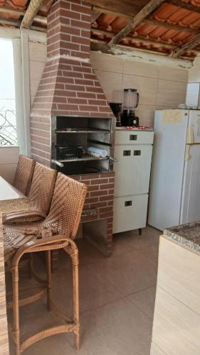 a kitchen with a brick oven and a refrigerator at Recharge your batteries Arca da Aliança Chalet in Limeira