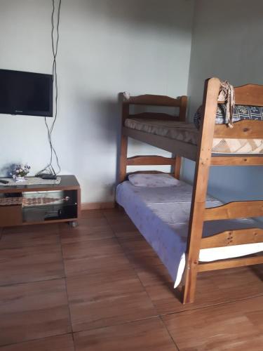 a room with a bunk bed and a television at Recharge your batteries Arca da Aliança Chalet in Limeira