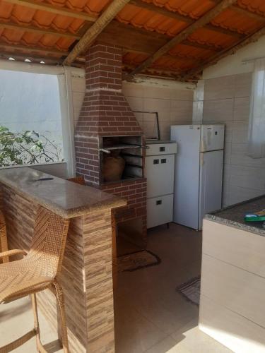 a kitchen with a brick oven and a refrigerator at Recharge your batteries Arca da Aliança Chalet in Limeira