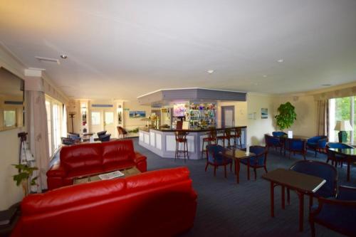 a living room with red furniture and a bar at Penmere Manor Hotel in Falmouth