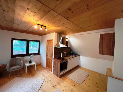 a living room with wooden ceilings and a kitchen at Apartmán Kunratice 2 in Kunratice