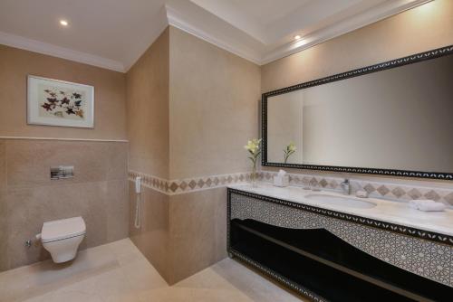 a bathroom with a sink and a toilet and a mirror at Steigenberger Resort Alaya Marsa Alam - Red Sea - Adults Friendly 16 Years Plus in Coraya Bay