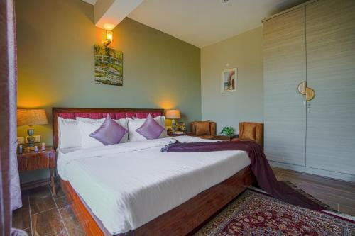 a bedroom with a bed with white sheets and purple pillows at SaffronStays Edelweiss Estate Amore in Chaubattia