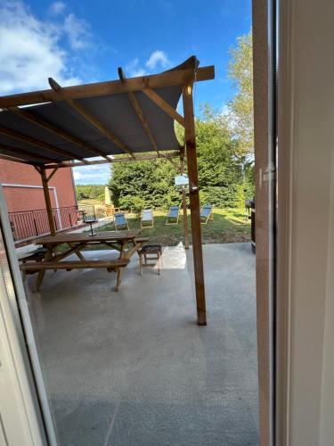 an outside view of a patio with a table and chairs at Gite Clé des Champs in Montenois