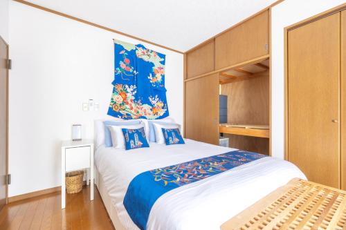 a bedroom with a large bed with blue and white pillows at NEW Koenji House 3BR Family Friendly Haven in Tokyo