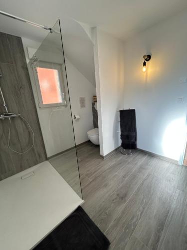 a bathroom with a glass shower and a toilet at Gite Clé des Champs in Montenois