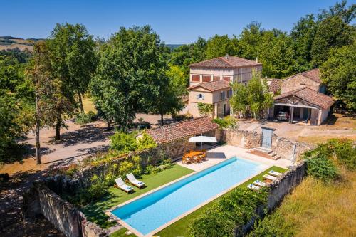 une vue aérienne d'une maison avec piscine dans l'établissement Bastide de Cordes sur Ciel - Piscine chauffée & Parc, à Cordes-sur-Ciel