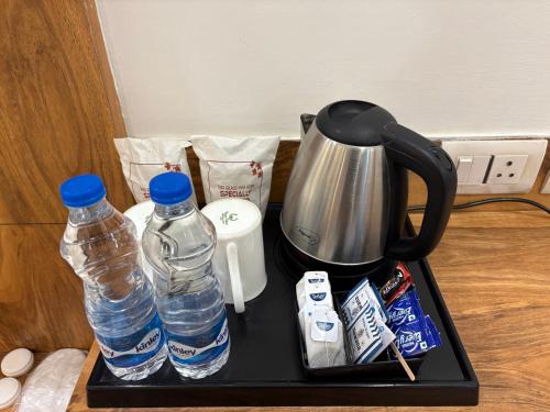 a tray with two bottles of water and a kettle at Hotel Golf View Sakura & Suites in Gurgaon