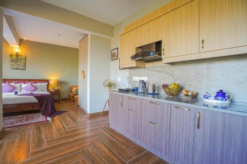 a kitchen with wooden floors and a bed in a room at SaffronStays Edelweiss Estate Amore in Chaubattia