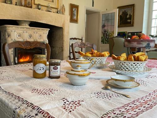 a table with a table cloth with food and a fireplace at Château de Miguillaume 