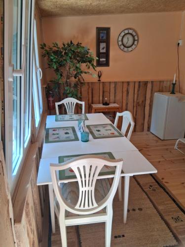 a dining room with a white table and chairs at Stuga im Wald mit Seeblick, nahe Vimmerby in Vena