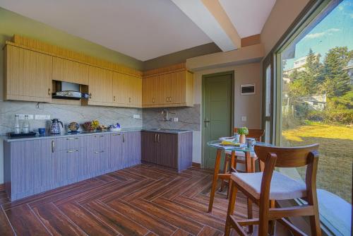 a kitchen with wooden cabinets and a table and chairs at SaffronStays Edelweiss Estate Amore in Chaubattia