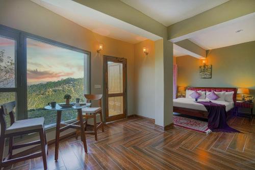 a bedroom with a bed and a table and chairs at SaffronStays Edelweiss Estate Amore in Chaubattia