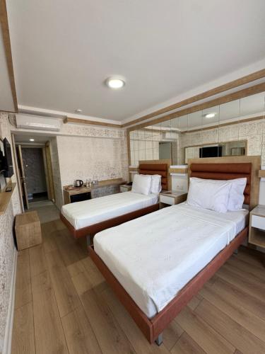 a bedroom with two beds and a kitchen at Alican 1 Hotel in Izmir
