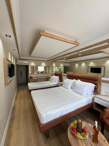 a large bedroom with two beds and a table at Alican 1 Hotel in Izmir