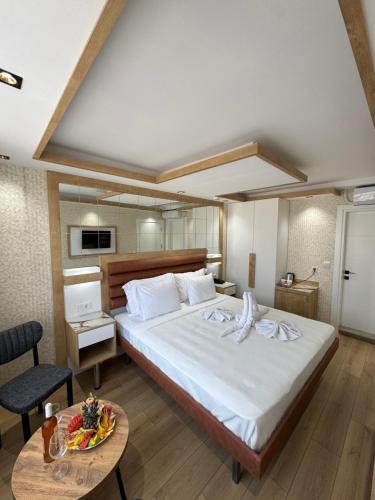 a bedroom with a large bed and a table at Alican 1 Hotel in Izmir
