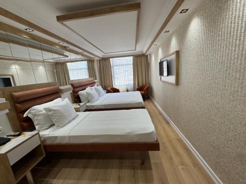 a hotel room with two beds and a window at Alican 1 Hotel in Izmir