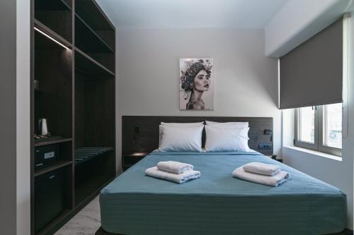 a bedroom with a bed with two towels on it at Envy Seaside Suites,By IdealStay Experience in Heraklion
