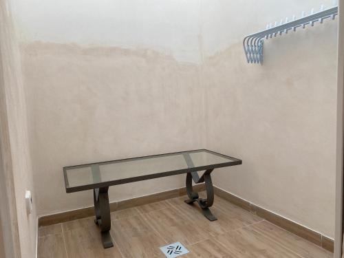 a glass table in a room with a wall at Isid'Oro Rooms - 100m from the sea in Sant'Isidoro
