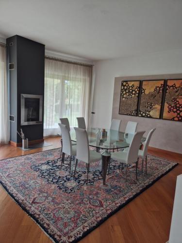 a dining room with a glass table and chairs at Villa in Langa in Belvedere Langhe