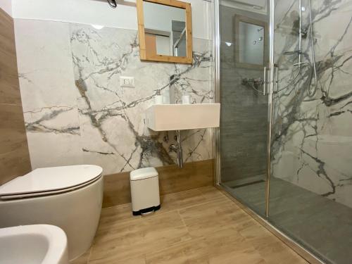 a bathroom with a toilet and a sink and a shower at Isid'Oro Rooms - 100m from the sea in Sant'Isidoro