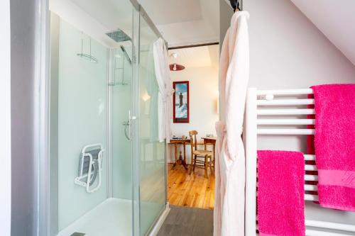 a bathroom with a glass shower and a dining room at Les gîtes de Lanevry 800m plage in Kerlaz