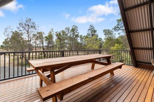eine Holzterrasse mit einem Picknicktisch darauf in der Unterkunft Spacious Barossa Retreat with Balcony Views in Tanunda