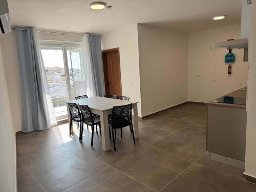 a kitchen and dining room with a table and chairs at Serenity Escape 2 Bed with Patio in Taʼ Penza