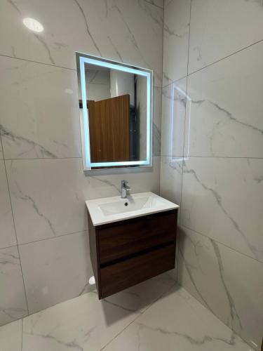 a white bathroom with a sink and a mirror at Serenity Escape 2 Bed with Patio in Taʼ Penza