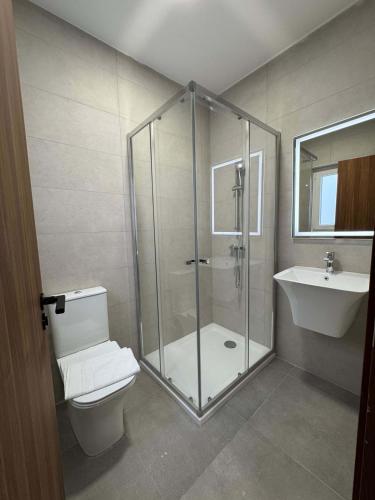 a bathroom with a shower and a toilet and a sink at Serenity Escape 2 Bed with Patio in Taʼ Penza