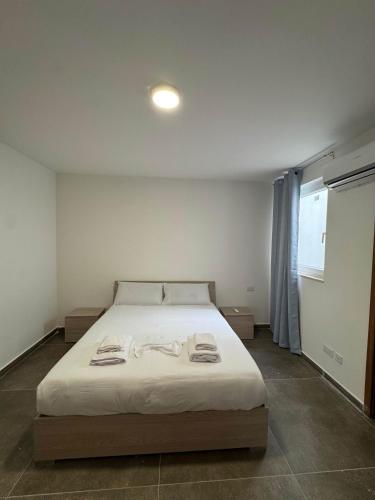 a bedroom with a large bed with towels on it at Serenity Escape 2 Bed with Patio in Taʼ Penza