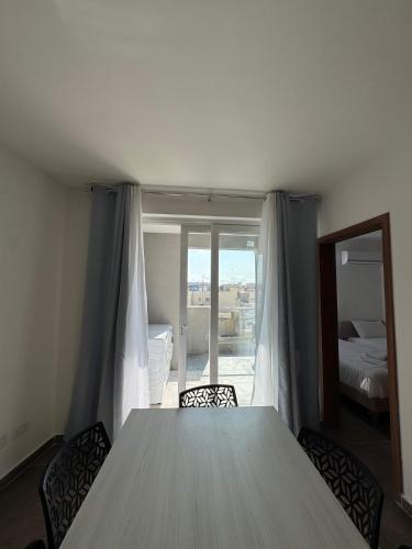 a table in a room with a view of a bedroom at Serenity Escape 2 Bed with Patio in Taʼ Penza